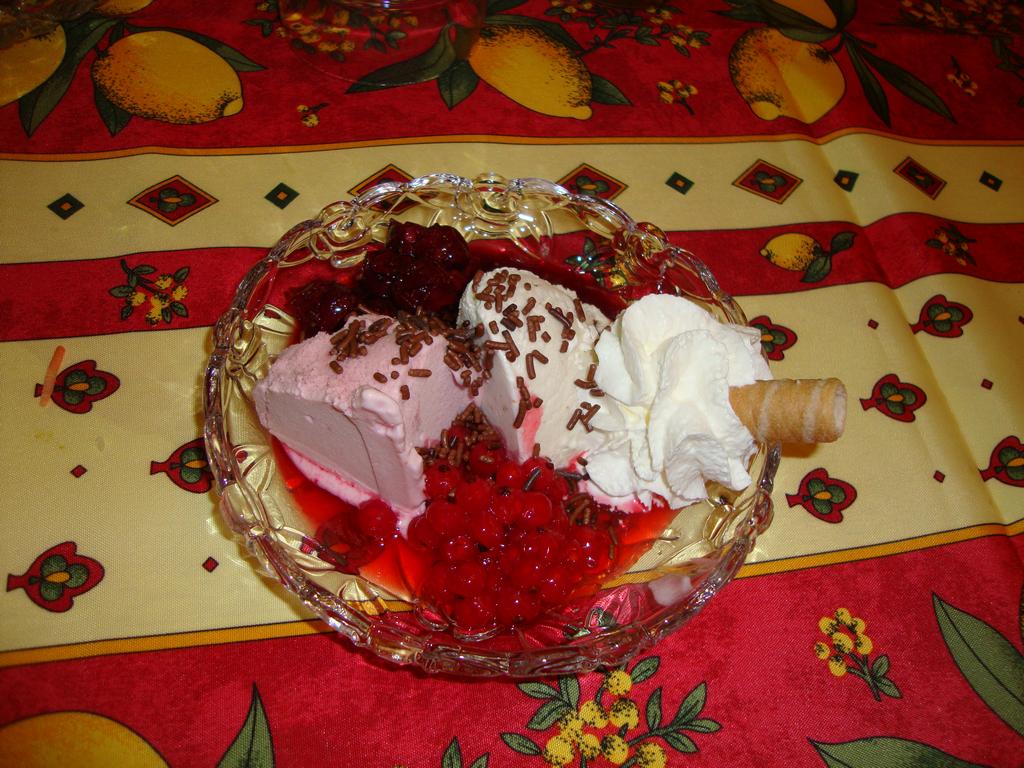 The fantastic dessert: two types of ice cream with fresh berries, whipped cream, and shaved chocolate.