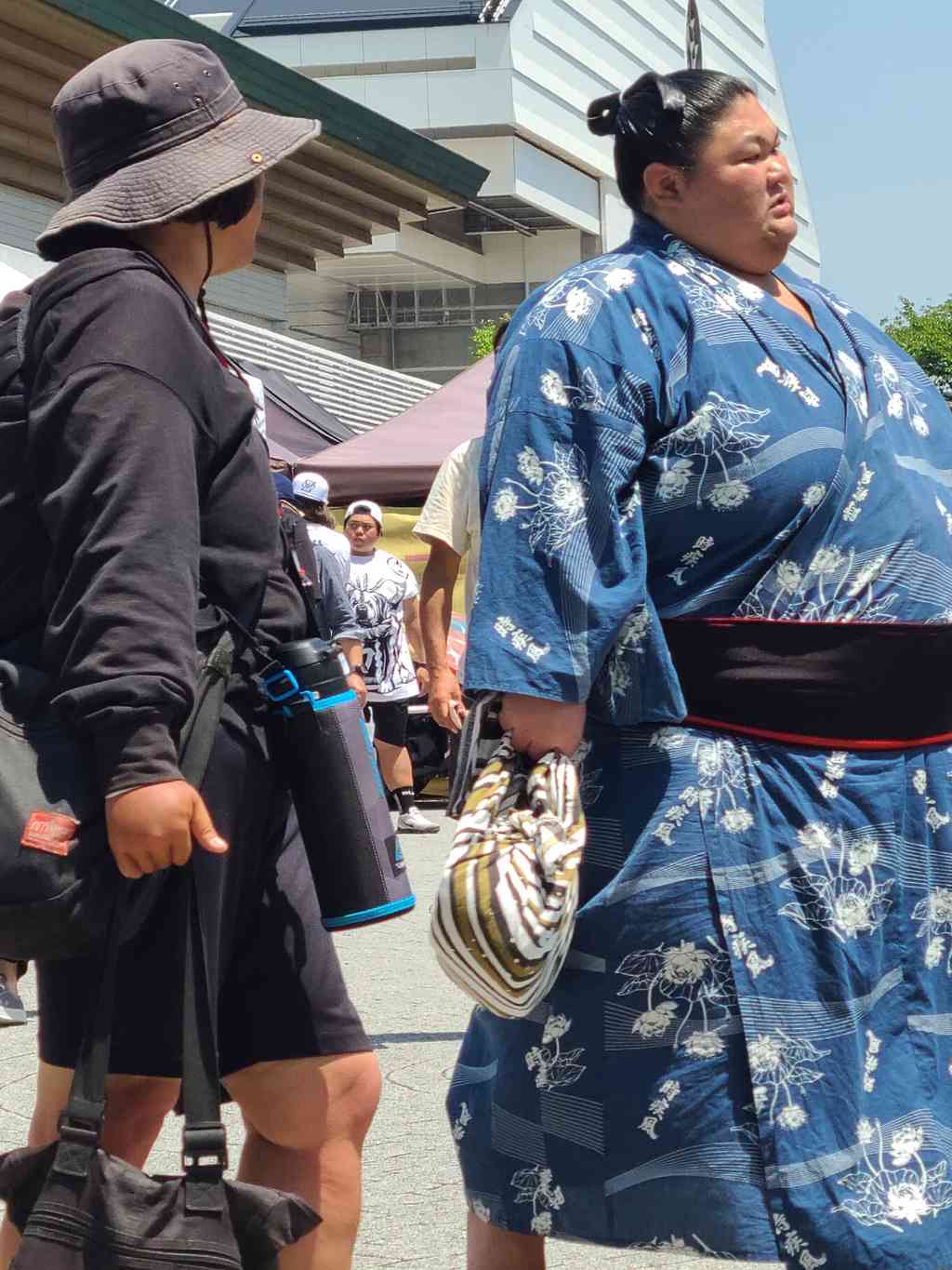 A towering wrestler heading to the train station after his match. I wonder if he won or lost...